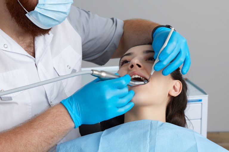 Dentista, mentre opera una otturazione su un dente